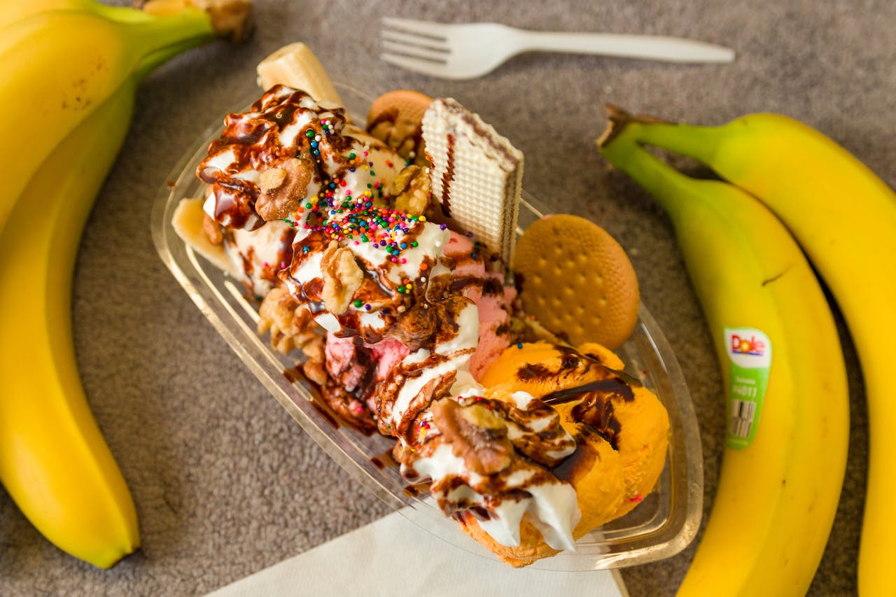Indulge in a sweet banana split topped with chocolate, sprinkles, and cookies.