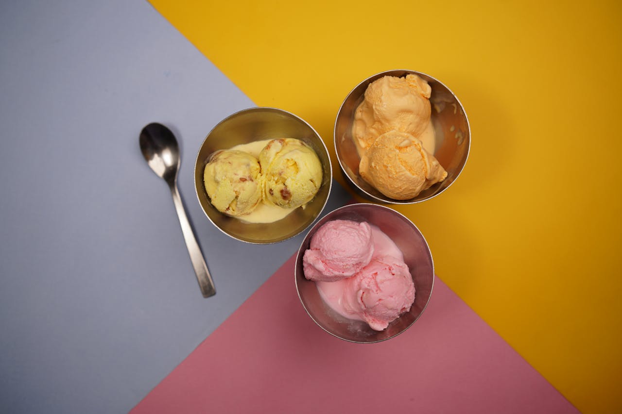 services-header Vibrant ice cream scoops in metal bowls on colorful background.