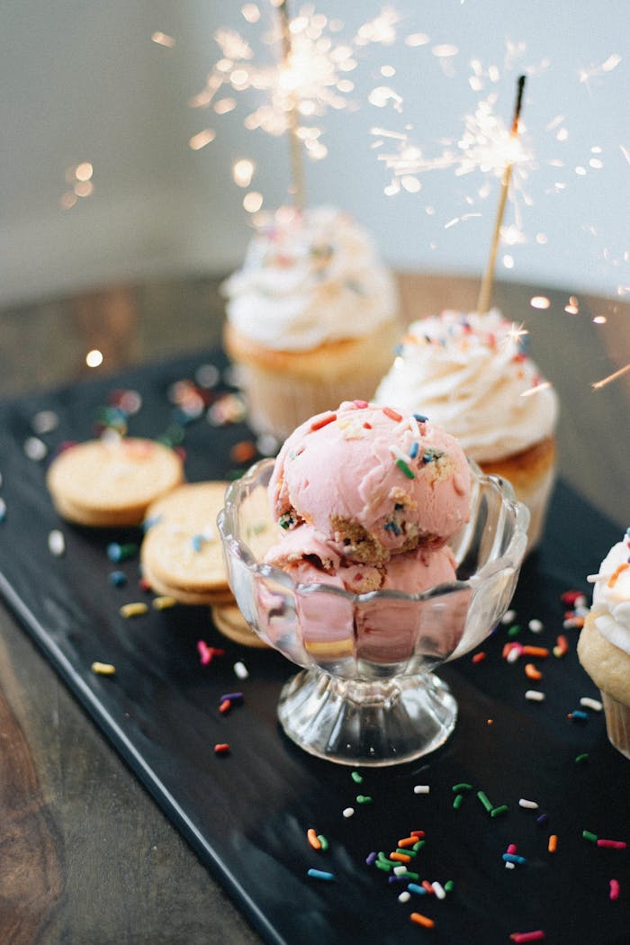 Stylish artisan dessert display featuring strawberry ice cream and sparkling cupcakes.
