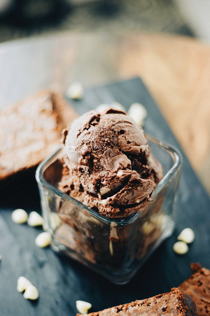 Elegant presentation of rich chocolate ice cream in a glass dish with brownies.