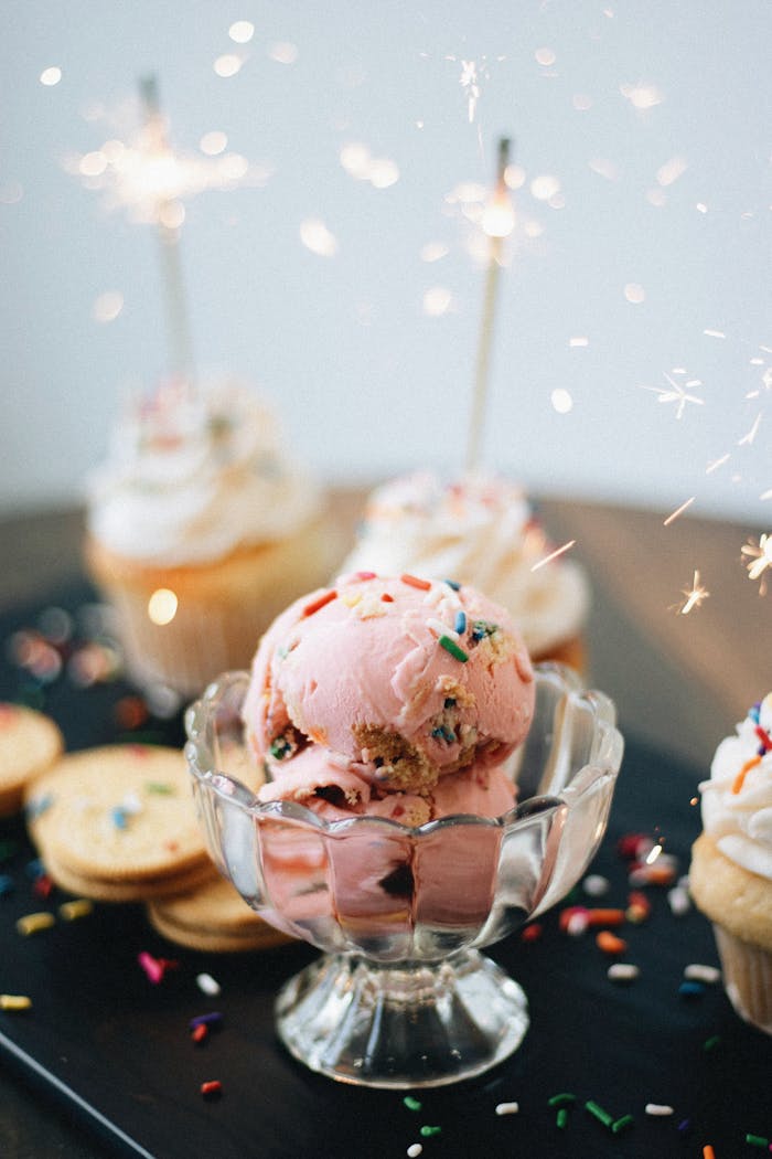 services-03 Delicious pink ice cream and cupcakes adorned with sparklers and sprinkles.