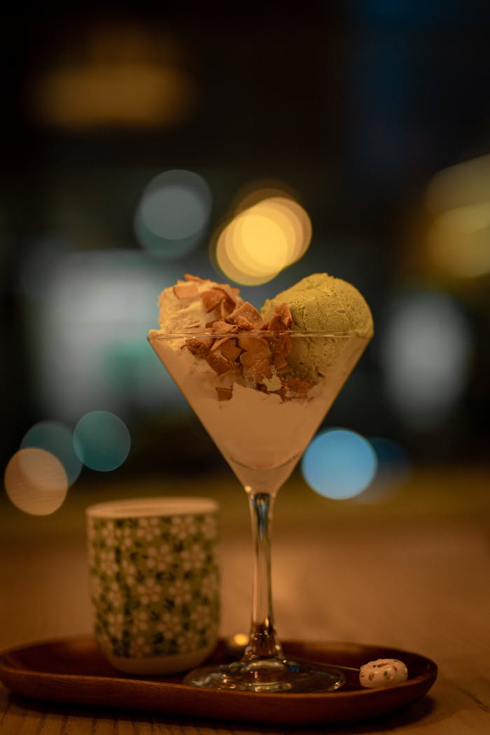 A tempting cup of matcha and vanilla ice cream garnished with flakes, perfect for dessert lovers.